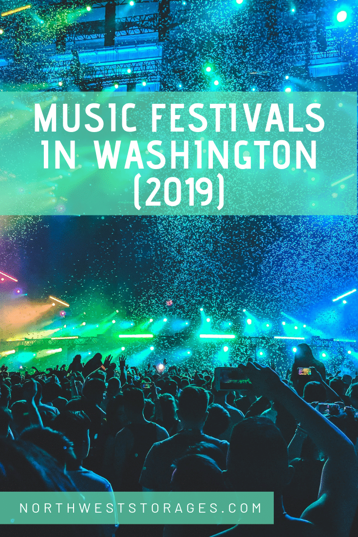 A crowd of people are standing in front of a stage at a music festival in washington.